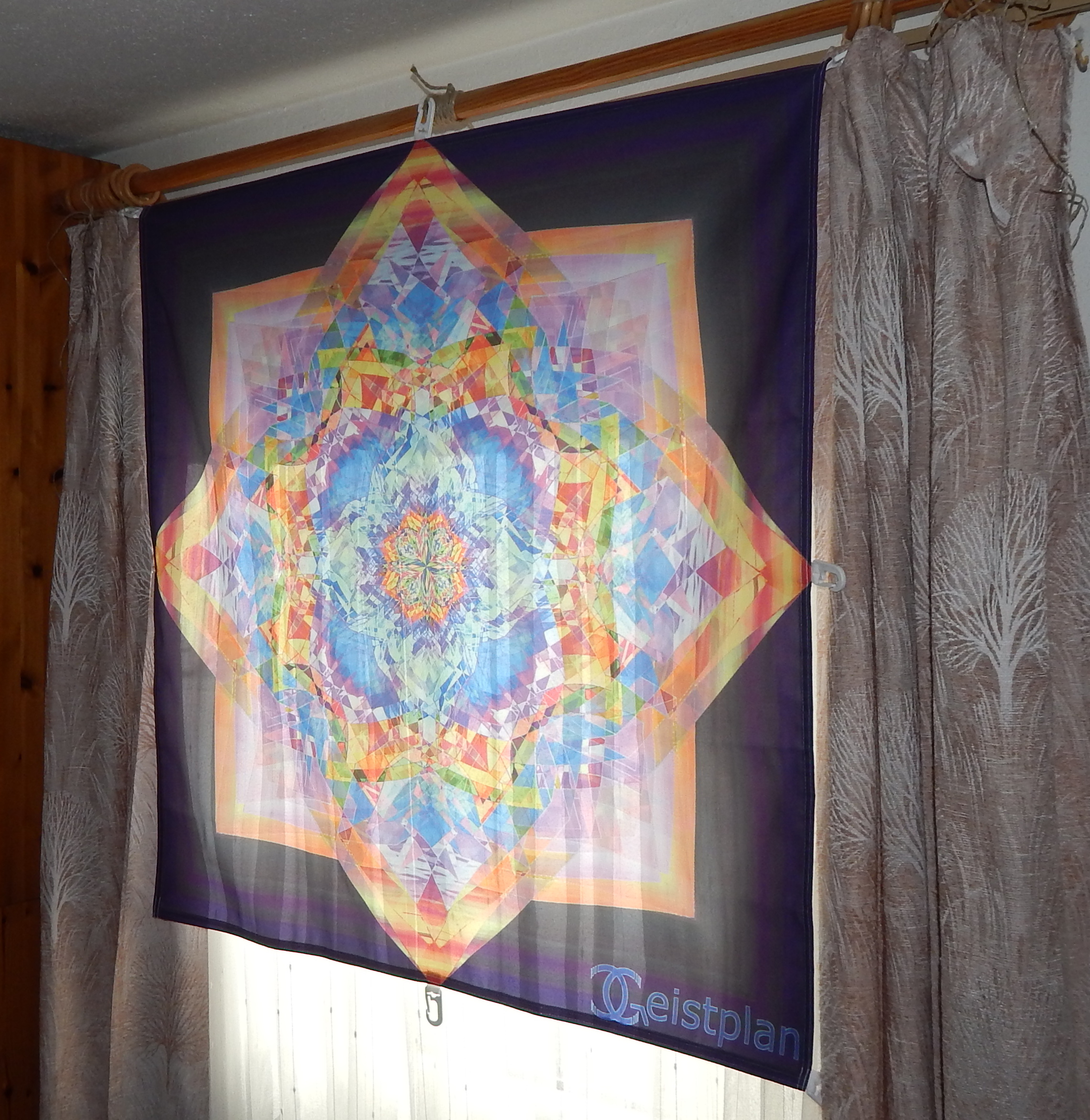 Buntes Mandala als Tuchdruck an einem Fenster. psychodelic mandala, psychodelisches Mandala