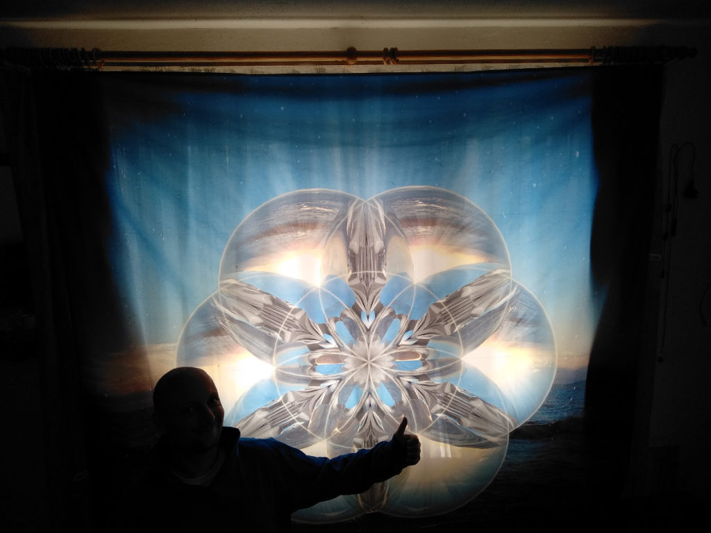 Wandbehang als Tuch als Vorhang, welches hinterleuchtet wird von der Sonne. Blaue Muster