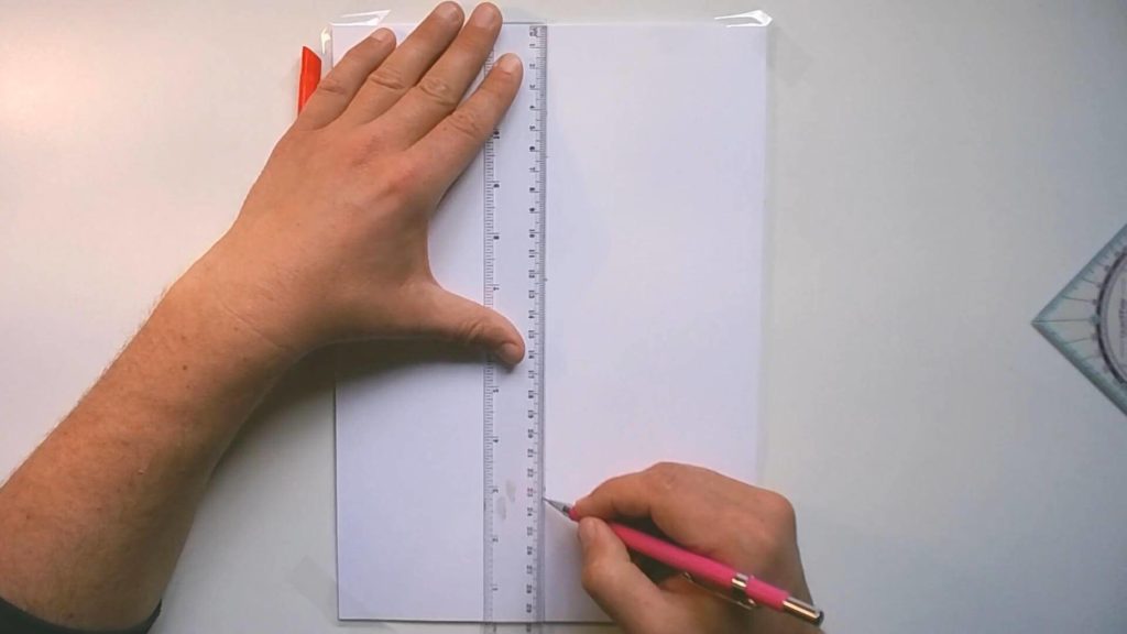 Bild mit einem hochkant DIN A4 Papier, auf dem Markierungen in der Senkrechten gesetzt werden.